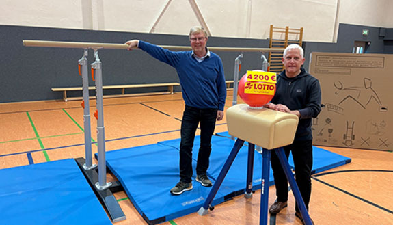 Zwei M&auml;nner stehen entspannt zwischen den neuen Ger&auml;ten. 