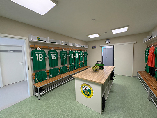 Die neugestalteten Kabinen der SG Eintracht Lossa mit Tisch in der Mitte, neuen B&auml;nken und Trikots an den Pl&auml;tzen.