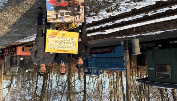Drei Mitglieder vom Traditionseisenbahnverein mit dem symbolischen Scheck von Lotto