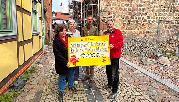 Personen mit F&ouml;rdercheck vor Kirche St. Nicolai Osterburg
