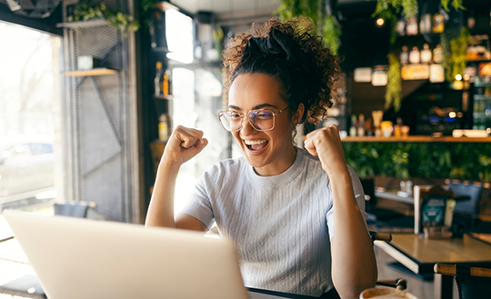 Frau jubelt am Laptop &uuml;ber den Gewinn von 100000 Euro bei SUPEr6