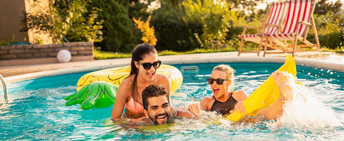 Ein Mann und zwei Frauen haben Spaß im Swimmingpool