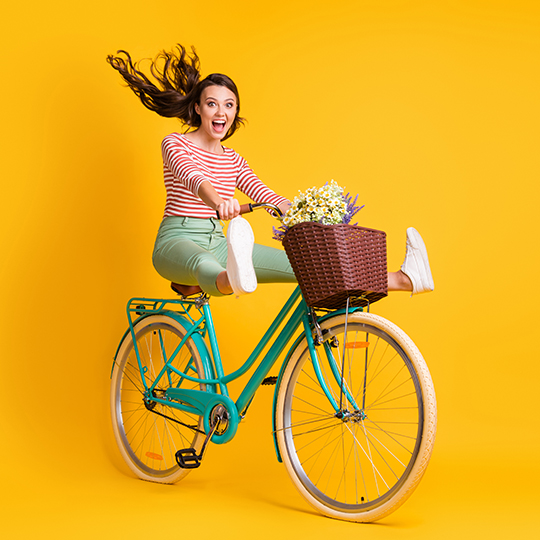 Frau auf einem Fahrrad, das die Beine hochh&auml;lt und lacht