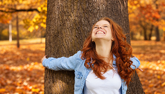 Person voller Freude in einem herbstlichen Wald