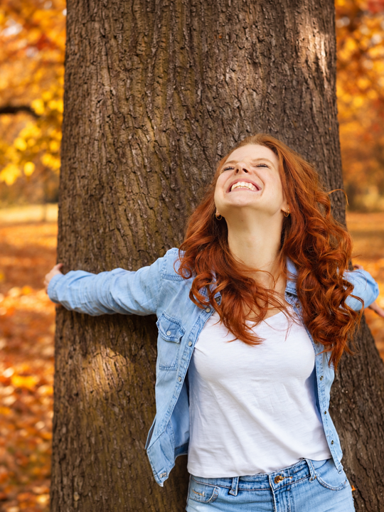 Person voller Freude in einem herbstlichen Wald
