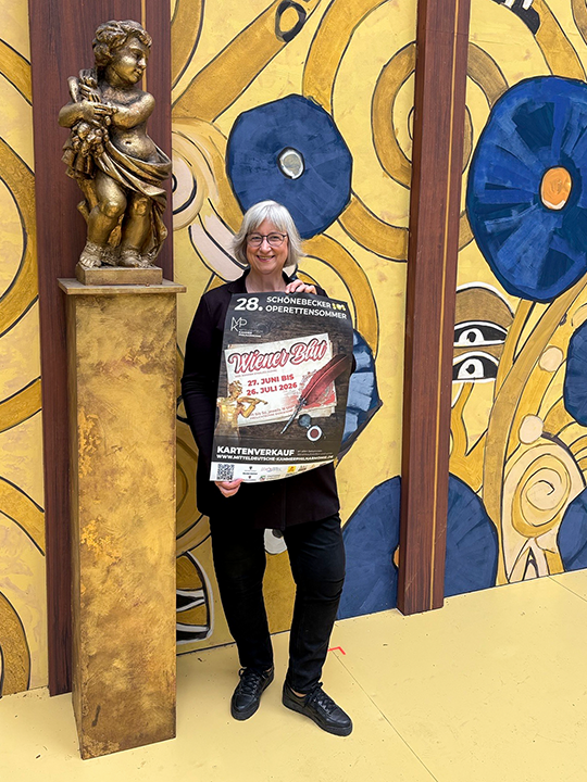 Anita Bader, Gesch&auml;ftsf&uuml;hrerin der Mitteldeutschen Kammerphilharmonie Sch&ouml;nebeck gGmbH, mit Plakat zu "Wiener Blut"