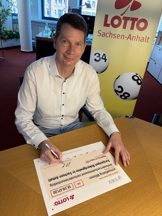 LOTTO Sachsen-Anhalt Geschäftsführer Stefan Ebert unterzeichnet symbolischem Scheck