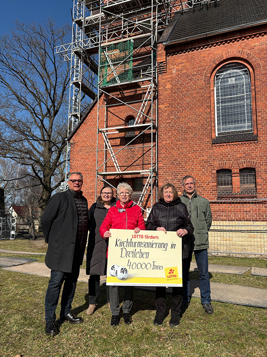 Gruppe von f&uuml;nf Leute mit symbolischem Spendenscheck von LOTTO Sachsen-Anhalt &uuml;ber 40.000 Euro f&uuml;r die Kirchturmsanierung von Dreileben