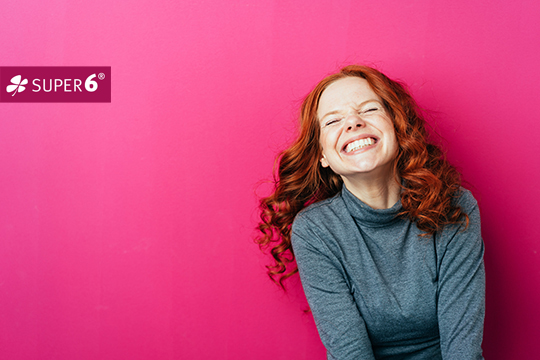 Junge Frau lacht vor Freude: Symbolbild zum Geldgewinn in den Zusatzlotterien Spiel 77 in Halle und Super 6 im Harz