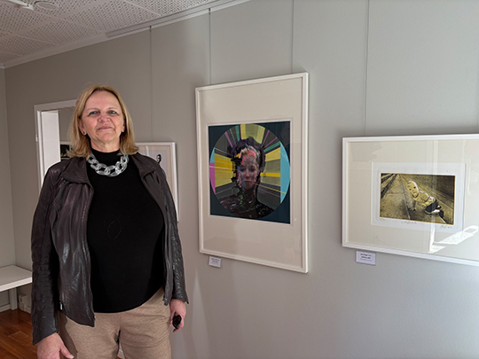 Vereinsvorsitzende des Halleschen Kunstverereins, Karola Waterstraat,  in der Druckgrafikausstellung in Halle: Sie steht in einem wei&szlig;en Raum mit Bildern an der Wand.